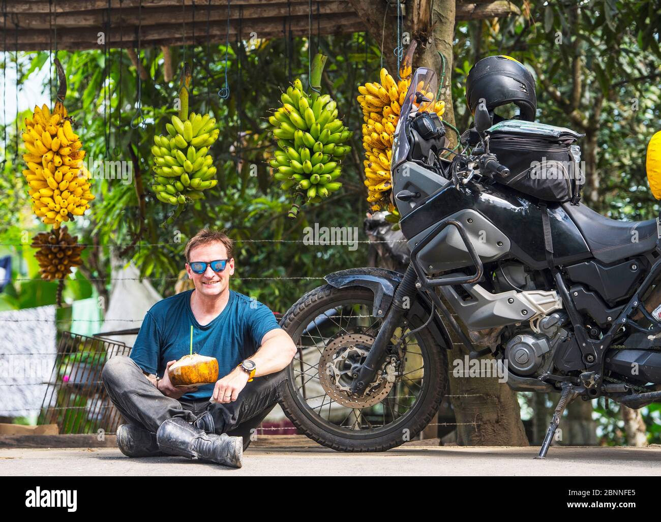 Motorbike rider enjoying local fruit, Machala, El Oro, Ecuador Stock Photo