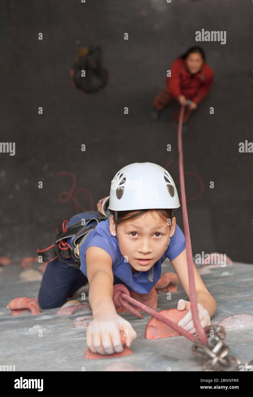 young girl climbing at indoor climbing wall in England / UK Stock Photo