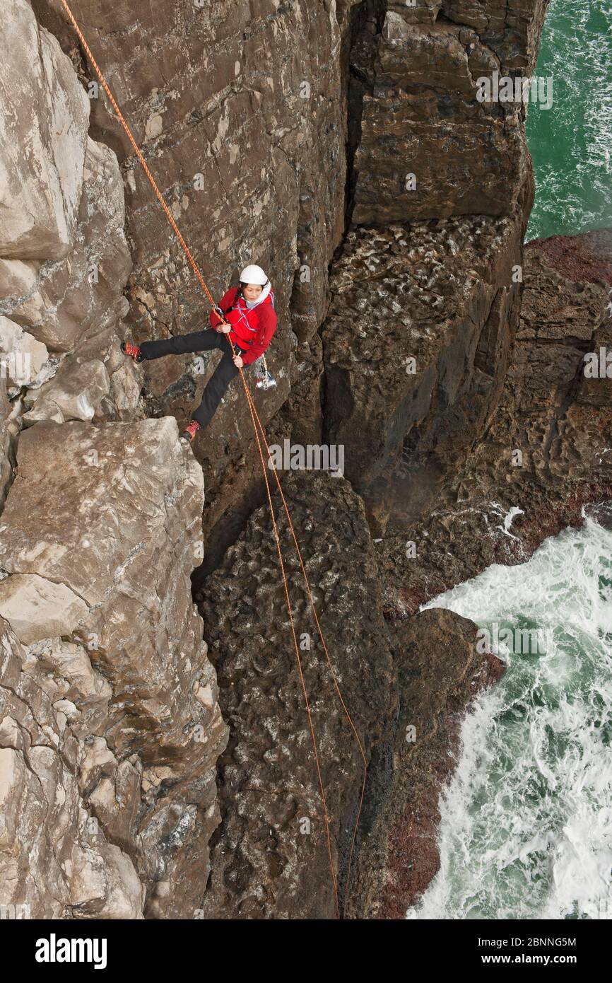 Female climber rappelling of seacliff in Swanage / England Stock Photo ...