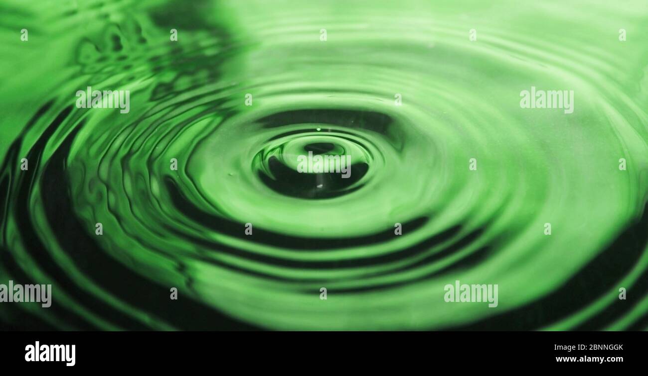 Water drop impact on water surface - Water droplet photography Stock Photo