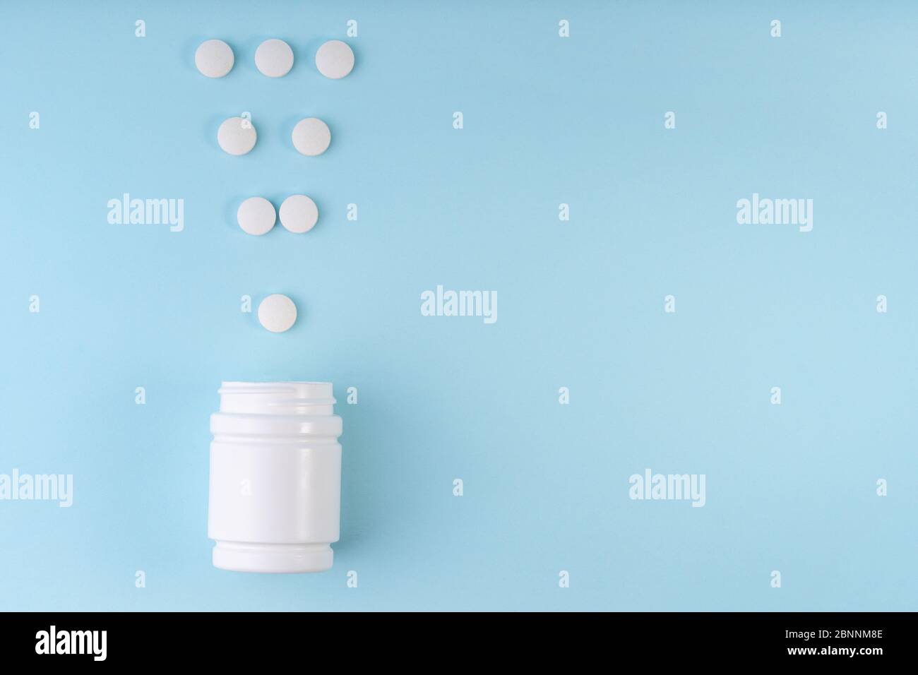 Exclamation point sign, mark from pharmaceutical medicine pills. Creative layout of tablets and bottle on blue. Exclamation symbol. Medicine, healthca Stock Photo