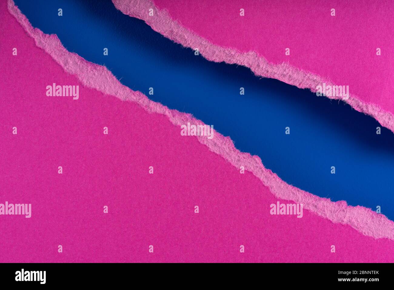 Pieces of torn ragged purple paper edges on blue background. Ripped