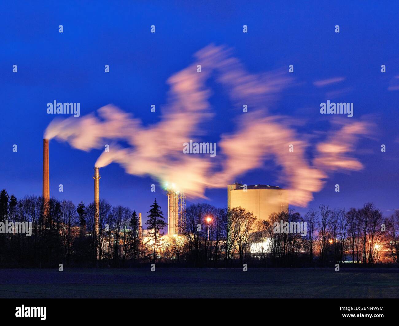 Industrial plant, silos, chimney, smoke, trees, evening mood, autumn Stock Photo