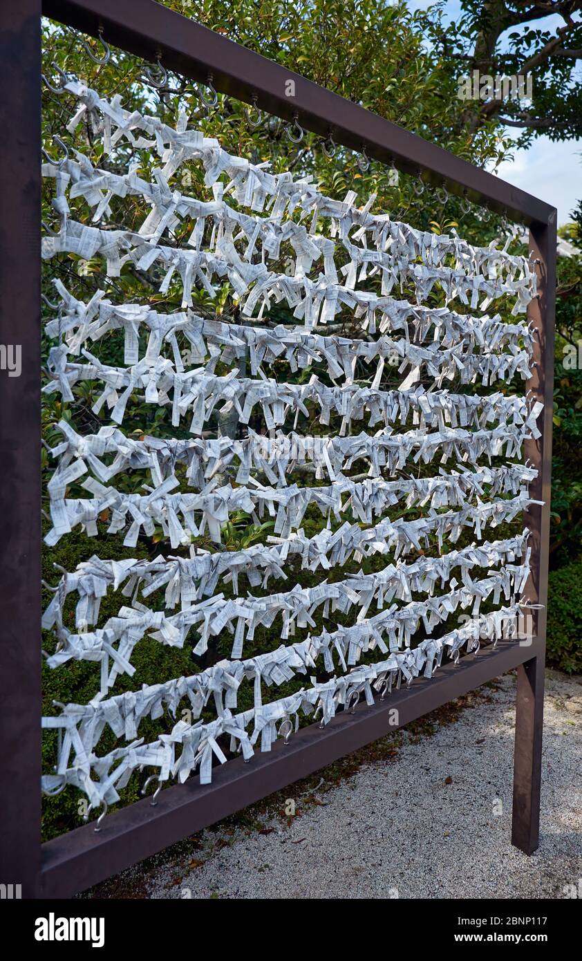 Omikuji, the fortune telling paper slips containing predictions, tying  around the strings at the Shikichi-jinja (Wara-tenjin) Shrine. Kyoto. Japan  Stock Photo - Alamy