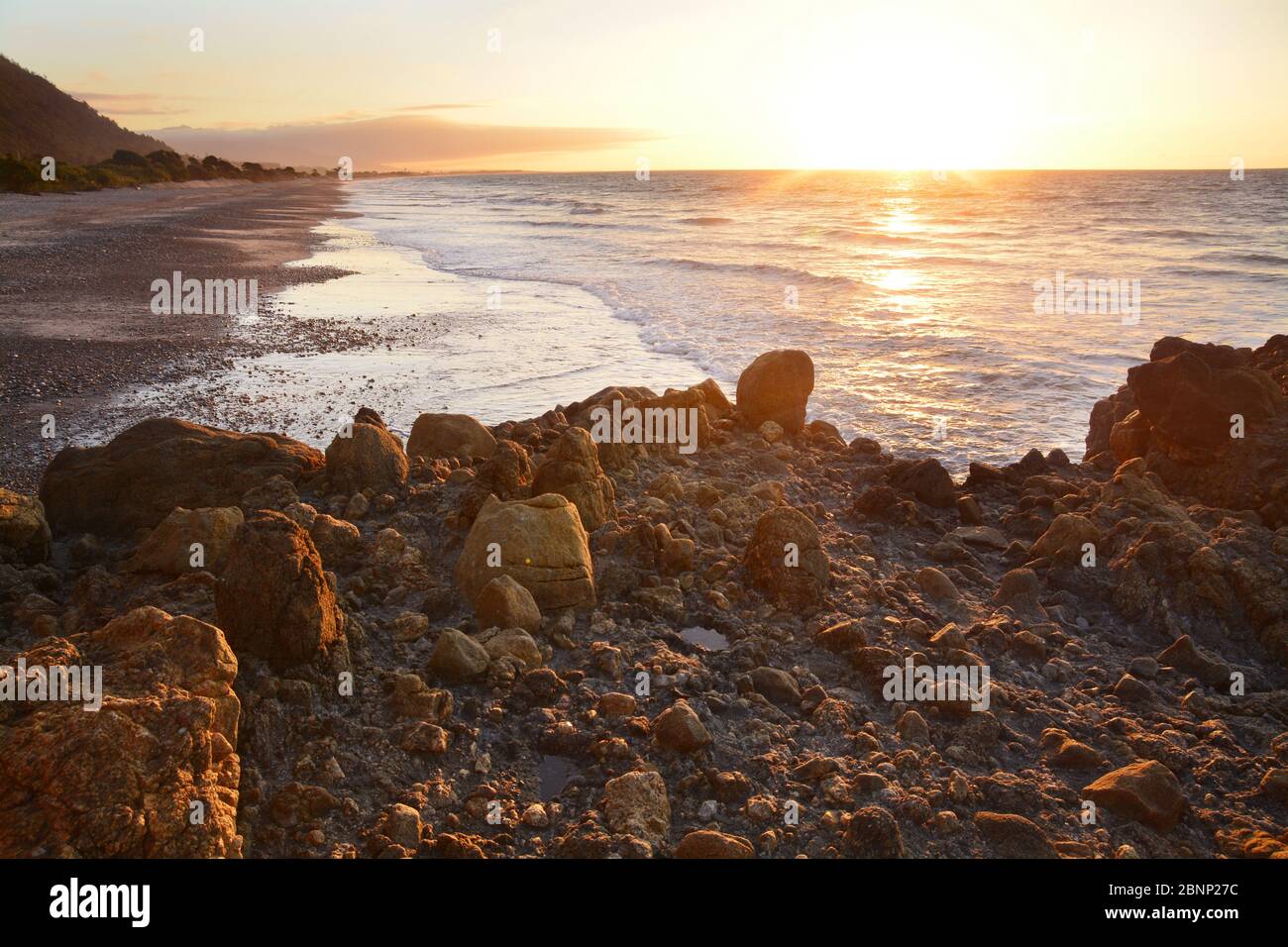 Sunset time with warm colors at the beach in Granity, New Zealand Stock Photo
