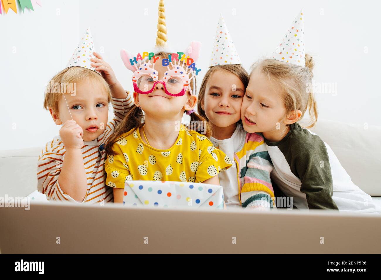 Funny little kids crowding in front of a laptop, having online birthday  party Stock Photo - Alamy