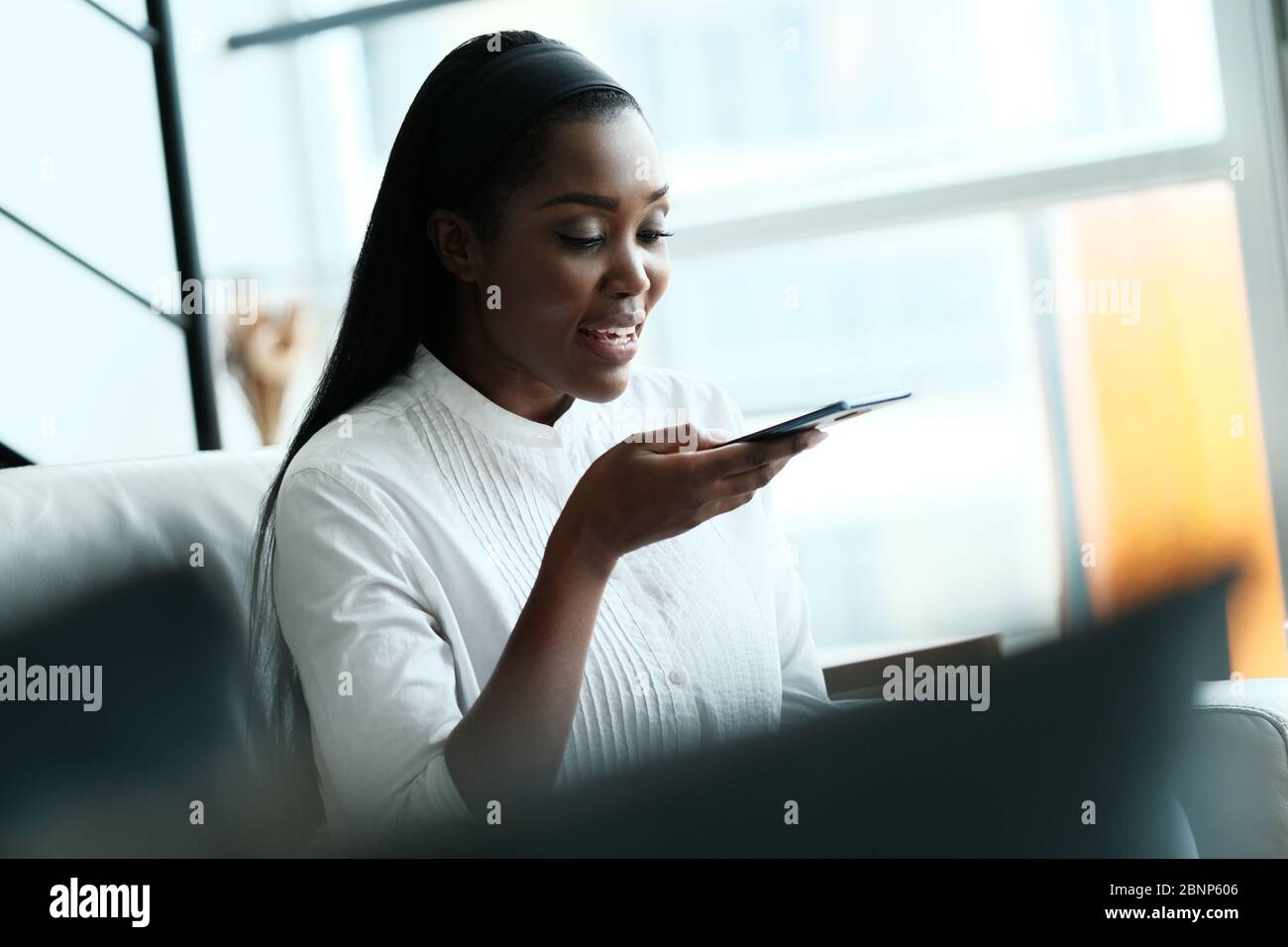 Black Woman Using Mobile Phone For Voice Mail Stock Photo