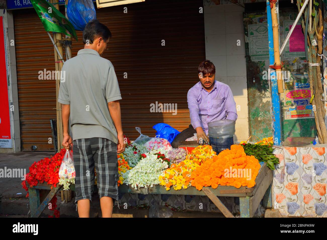 A man selling flowers by the roadside Stock Photo