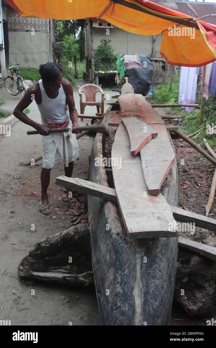 A man repairing a boat ahead of the monsoon in Majuli / pic by Ridip Borah Stock Photo
