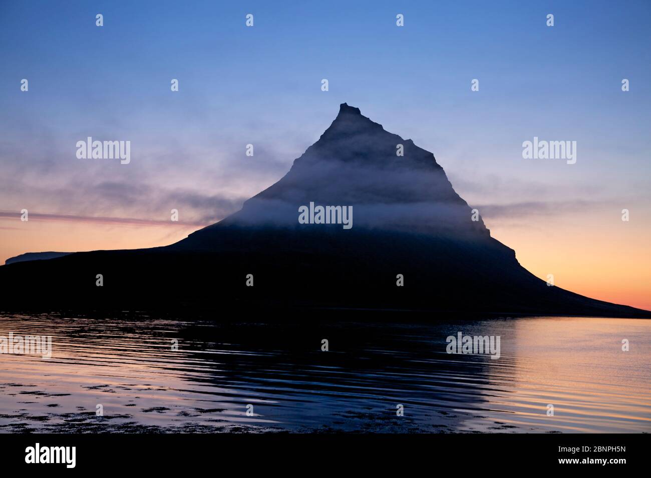 Clouds at Kirkjufell at Grundarfjoerdur Bay illuminated by the evening sun Stock Photo