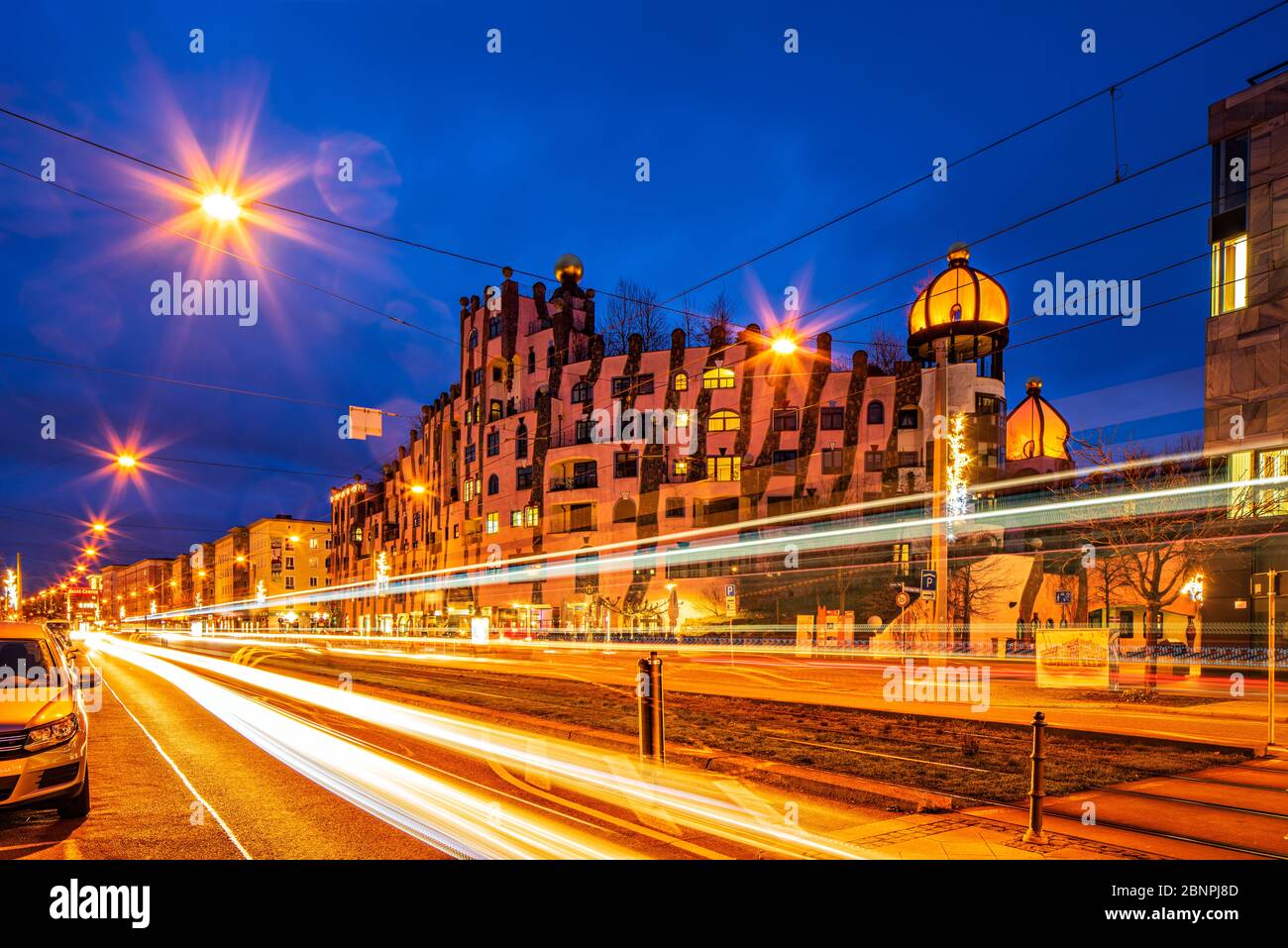 Germany, Saxony-Anhalt, Magdeburg, The Green Citadel, in front of light traces of the tram, night shot Stock Photo