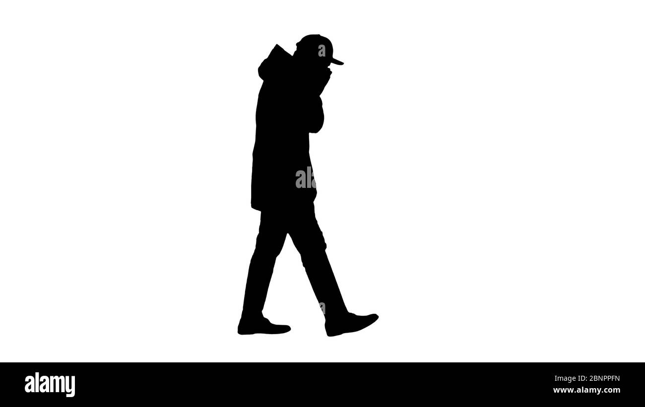 Silhouette Caucasian man in a hat and coat coughing walking. Stock Photo