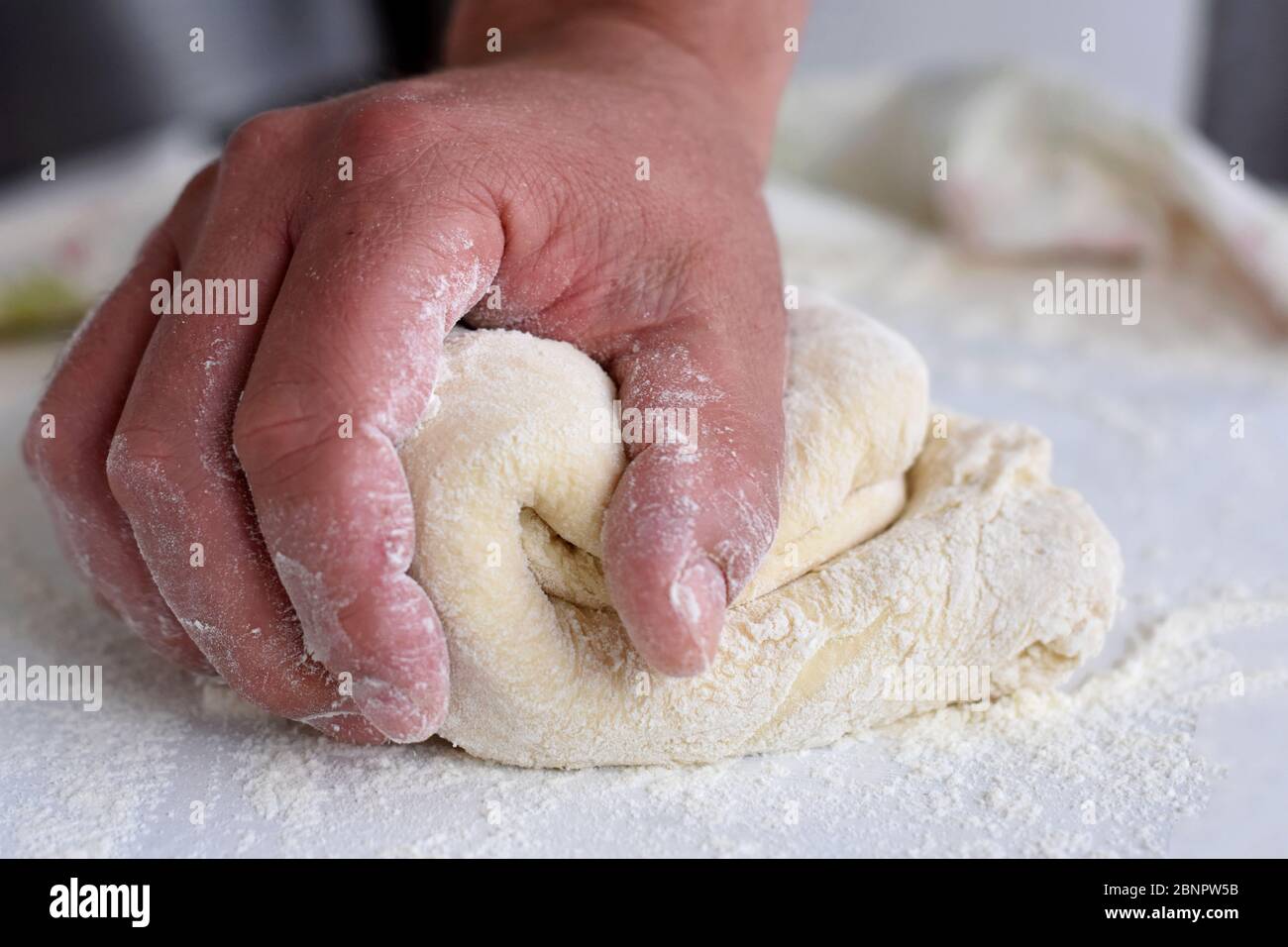 Bread making process. Closeup of man hands kneading dough. Baker
