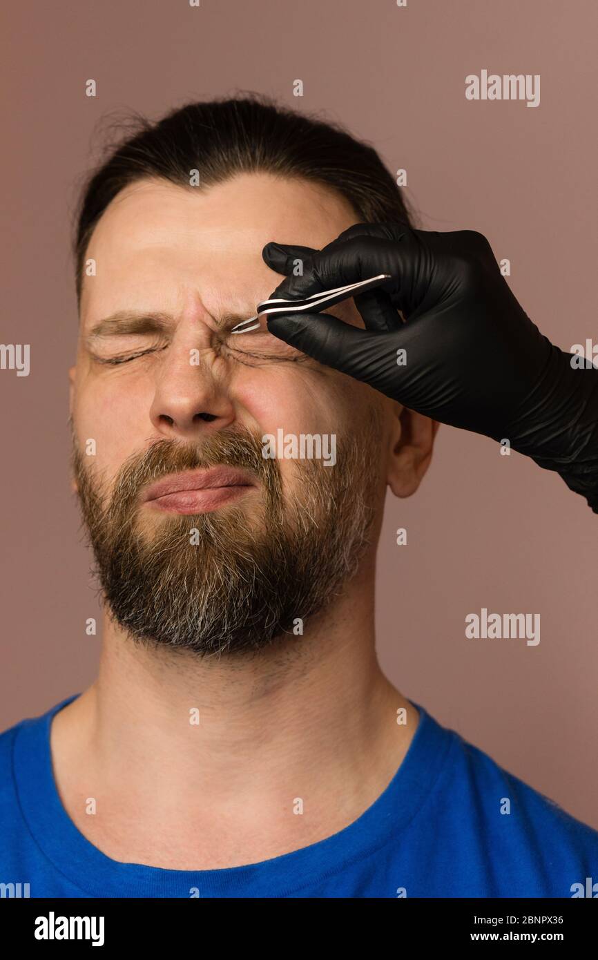 Professional barber doing threading procedure and correcting shape of