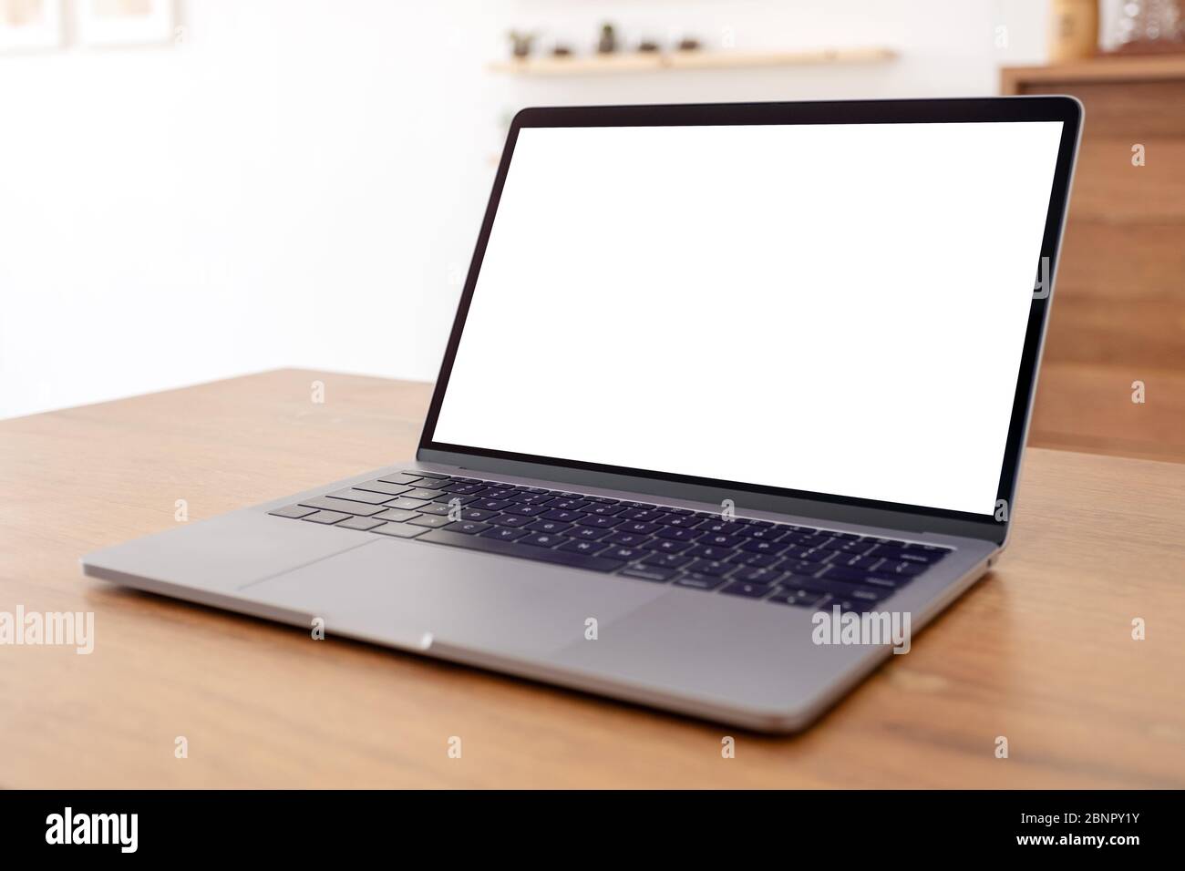 Mockup image of laptop with blank white desktop screen on wooden table ...