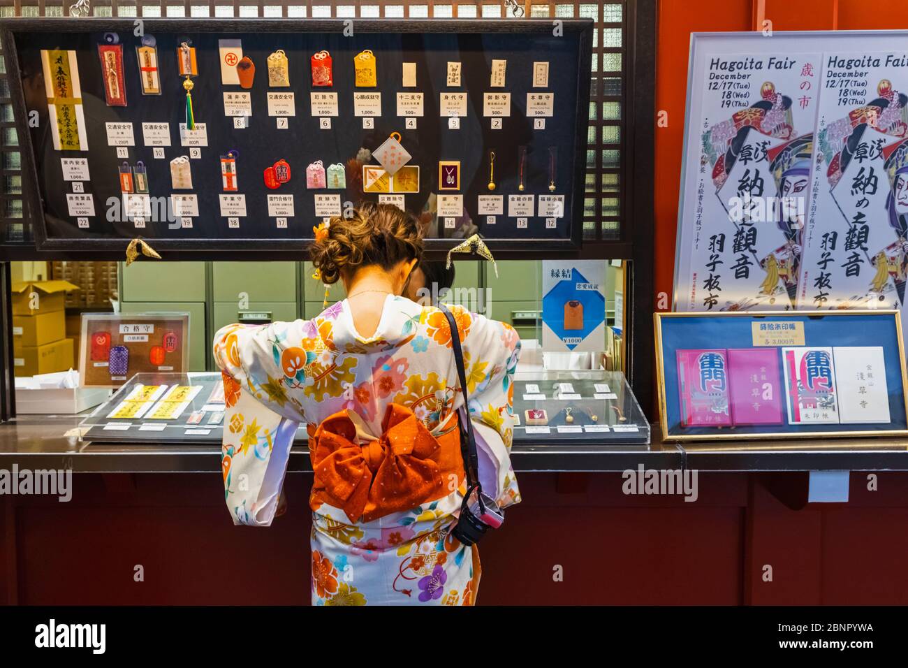 Japan, Honshu, Tokyo, Asakusa, Sensoji Temple, Woman in Kimono Buying Temple Souvenirs Stock Photo