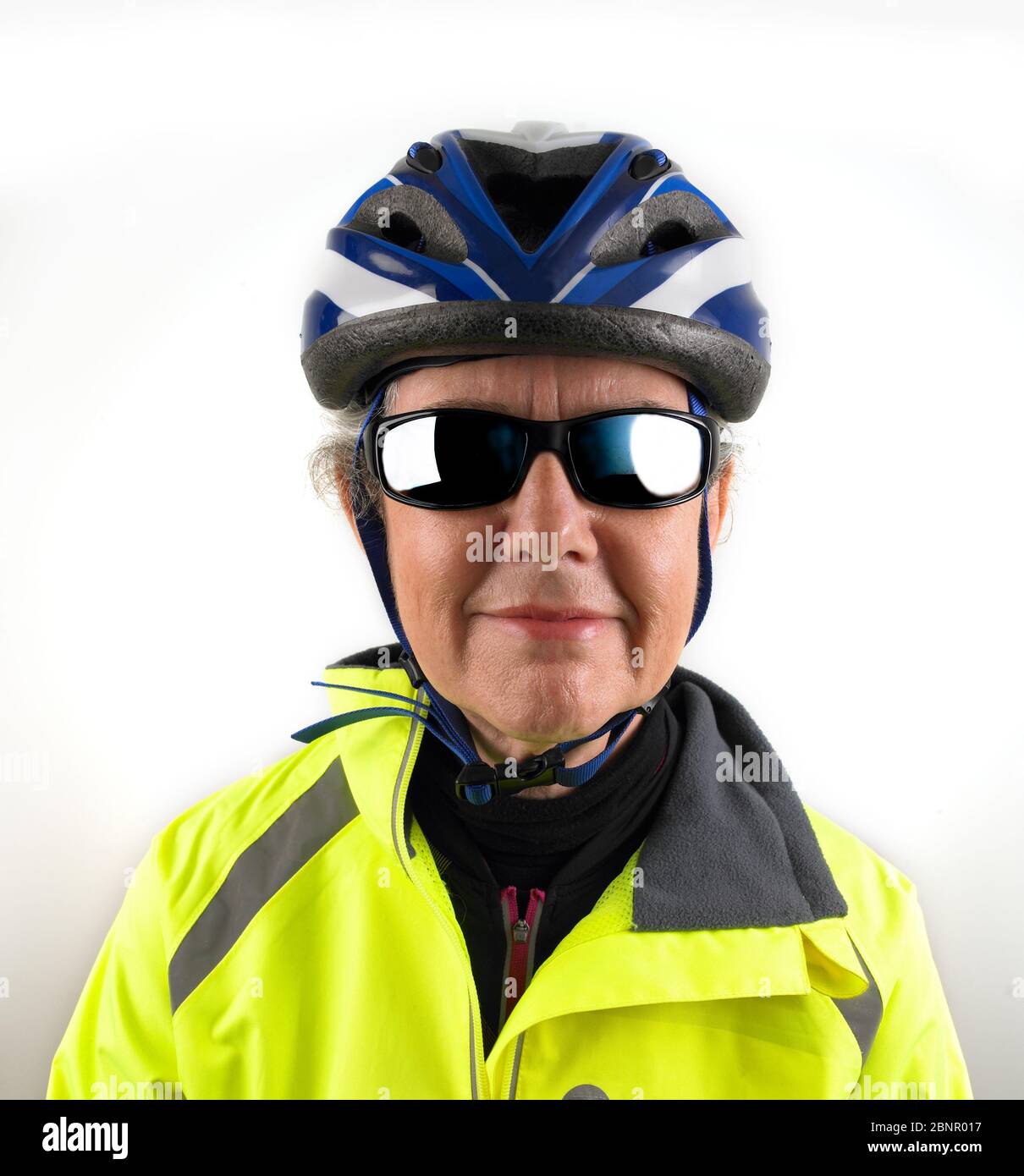 Woman cyclist wearing helmet and high visibility jacket Stock Photo