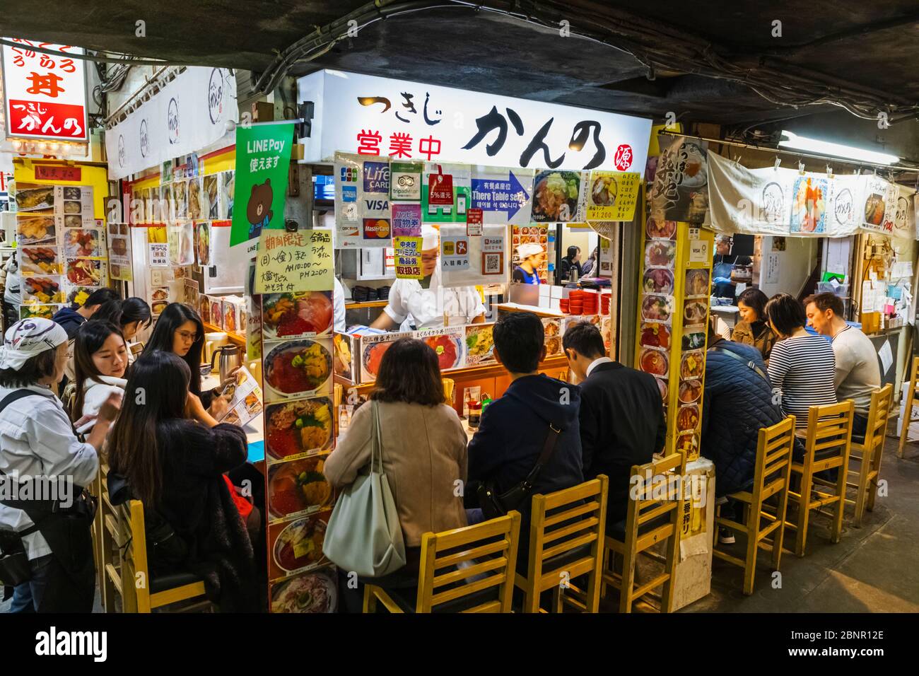 Japan, Honshu, Tokyo, Tsukiji, Tsukiji Outer Market, Seafood Restaurant with Customers Sitting at the Counter Stock Photo