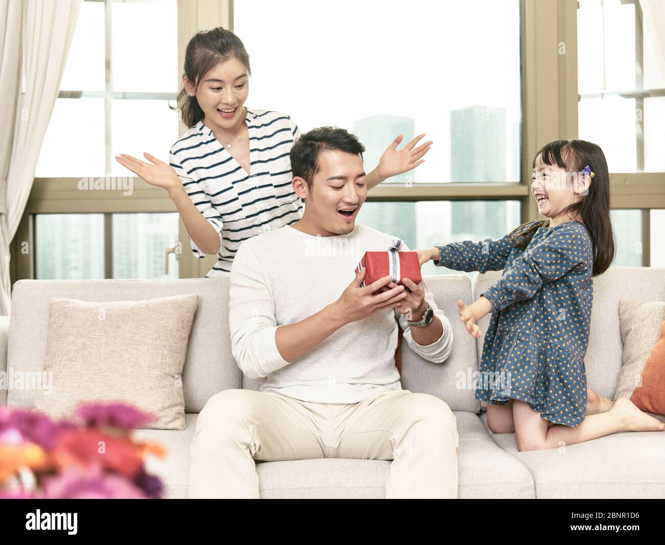little asian girl giving father a birthday gift Stock Photo