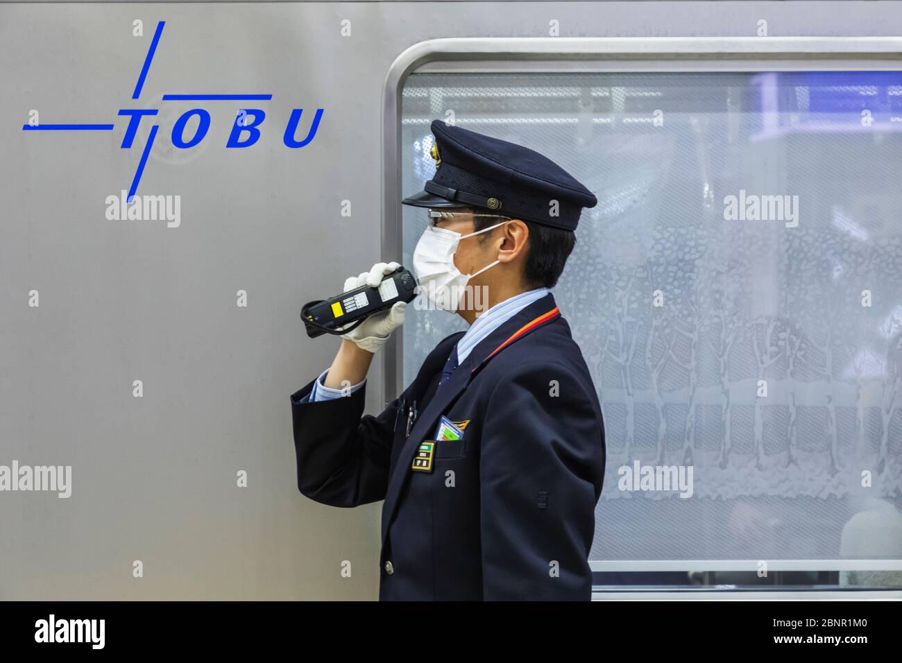 Japan, Honshu, Tokyo, Asakusa Station, Tobu Railways, Platform Guard Announcing Train Departure Stock Photo