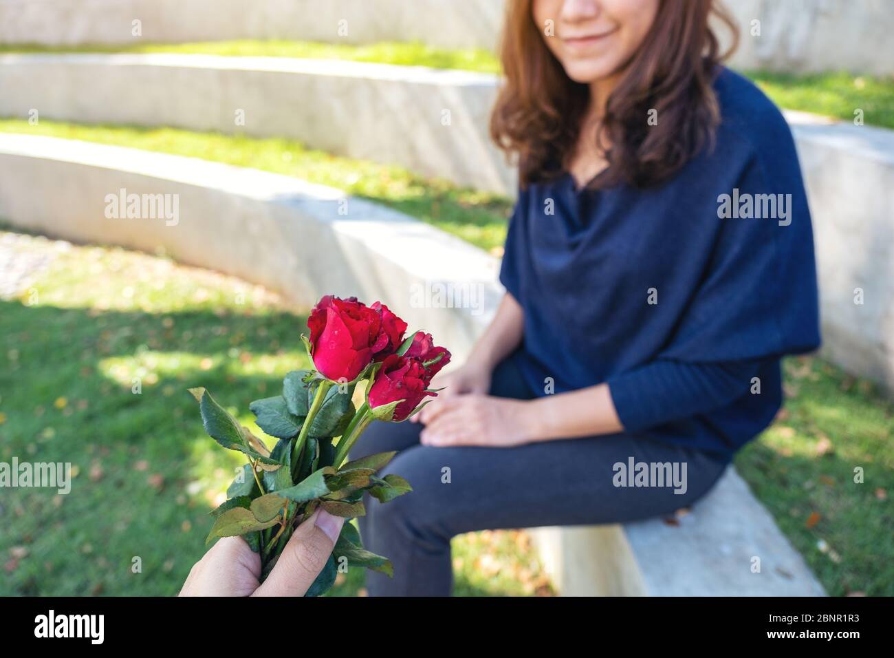 A man giving red rose flowers to beautiful girlfriend on Valentine's