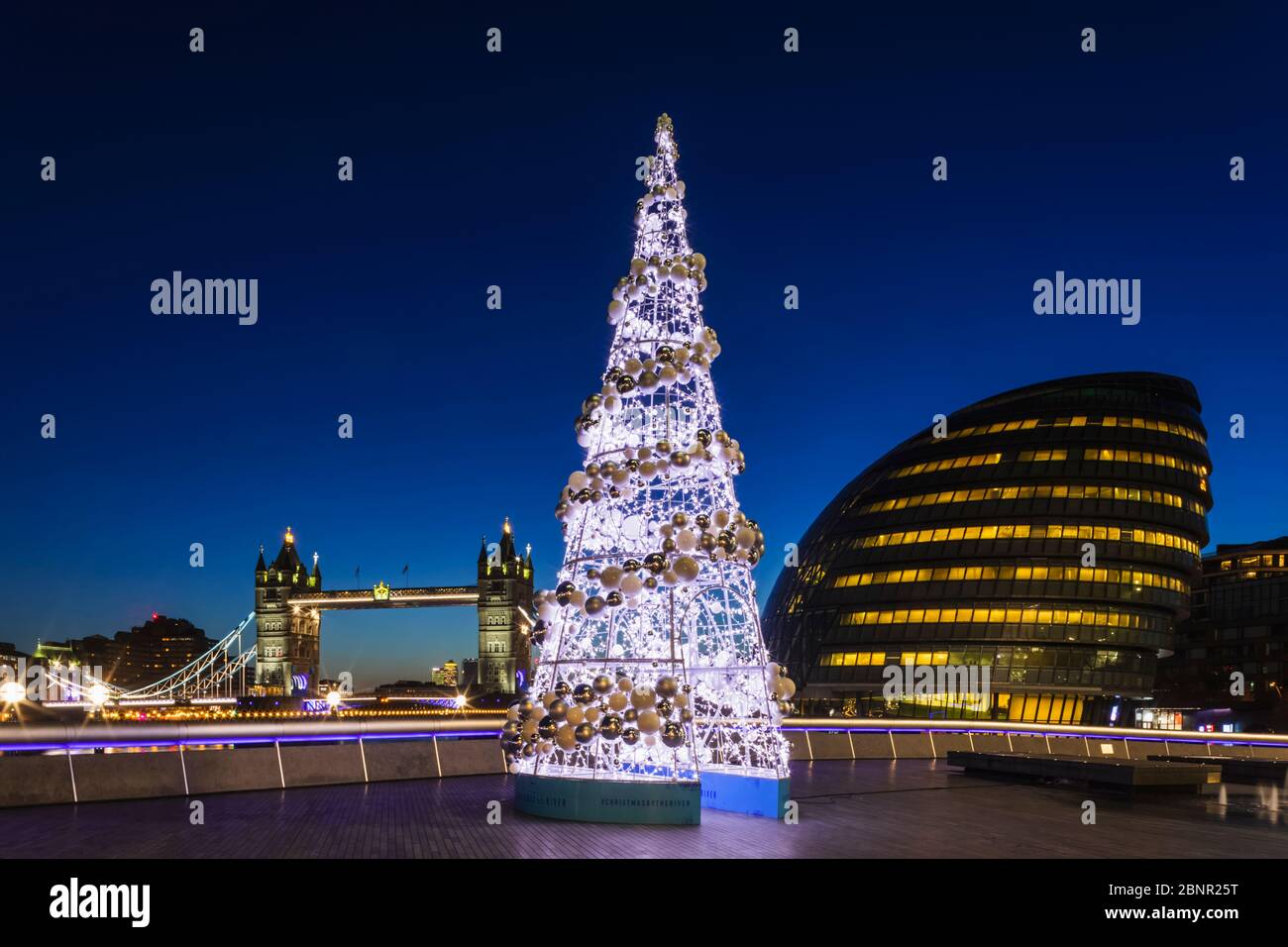 England, London, Southwark, City Hall and Tower Bridge at Night with Eletronic Christmas Tree in Foreground Stock Photo