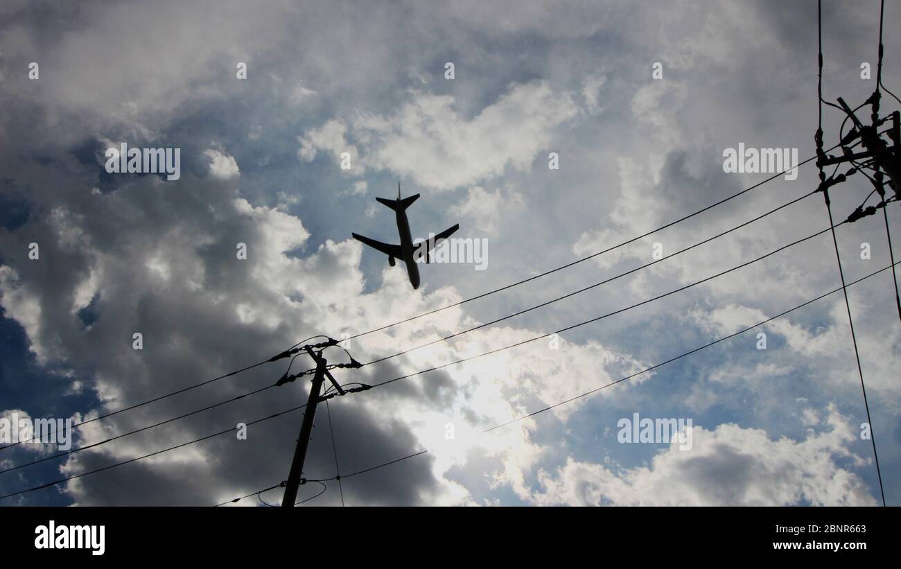 Jet airliner flying at a low height over a residential area Stock Photo