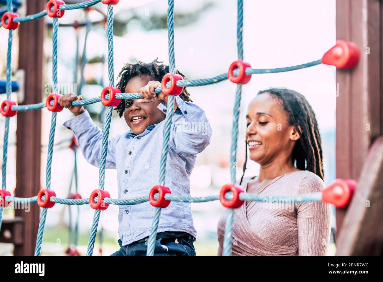 Mother and young kid son african black race play together at the playground  park having fun and enjoying the outdoor leisure activity - family with  dreadlocks hair ethnic style Stock Photo - Alamy