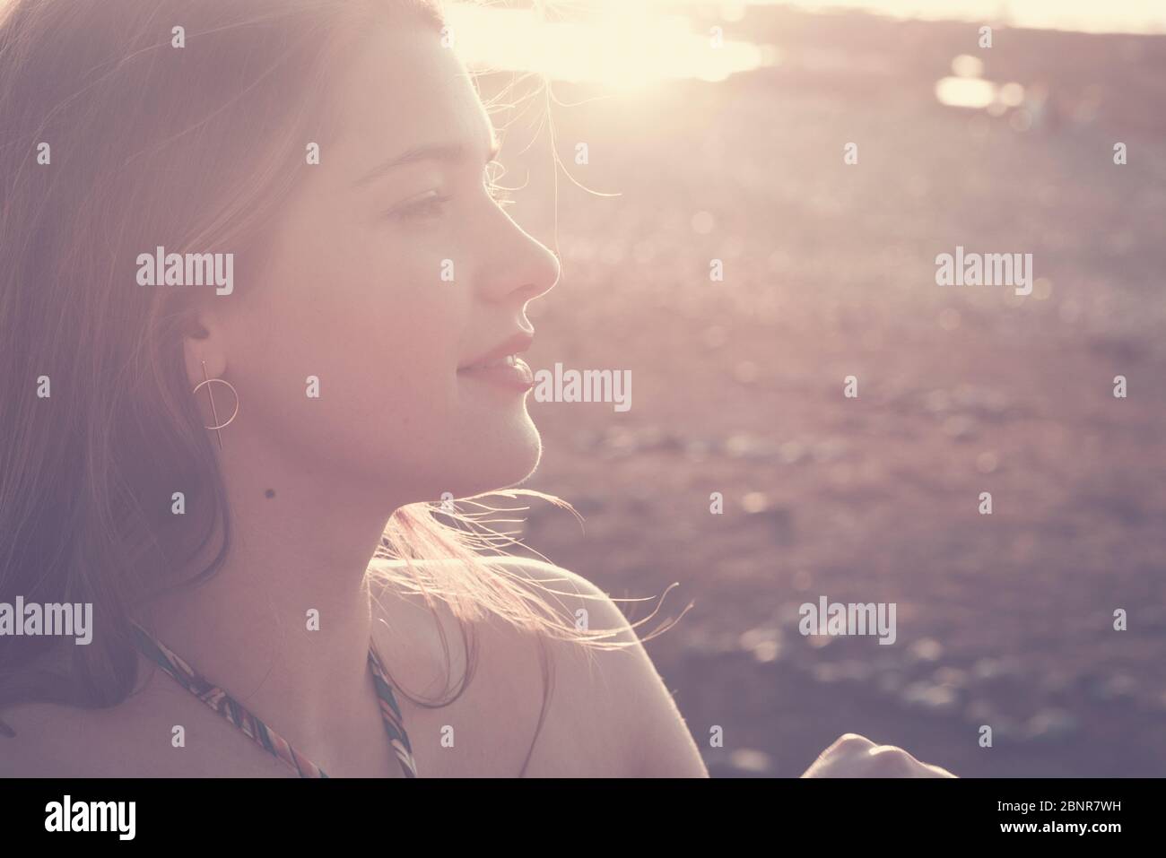 Wonderful young caucasian girl in sunny vintage colors portrait - caucasian beauty model female with sun in backlight and background - outdoor leisure activity lady Stock Photo