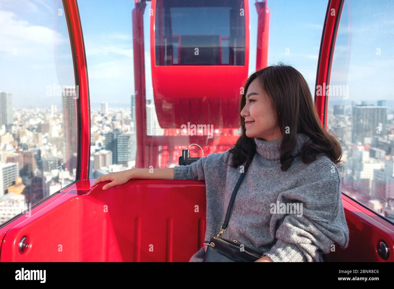 A beautiful asian woman riding a red ferris wheel in Japan Stock Photo