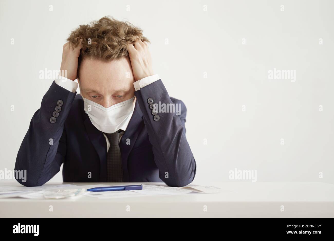 Despairing Businessman in Face Mask. Lockdown Coronavirus Concept. Stock Photo