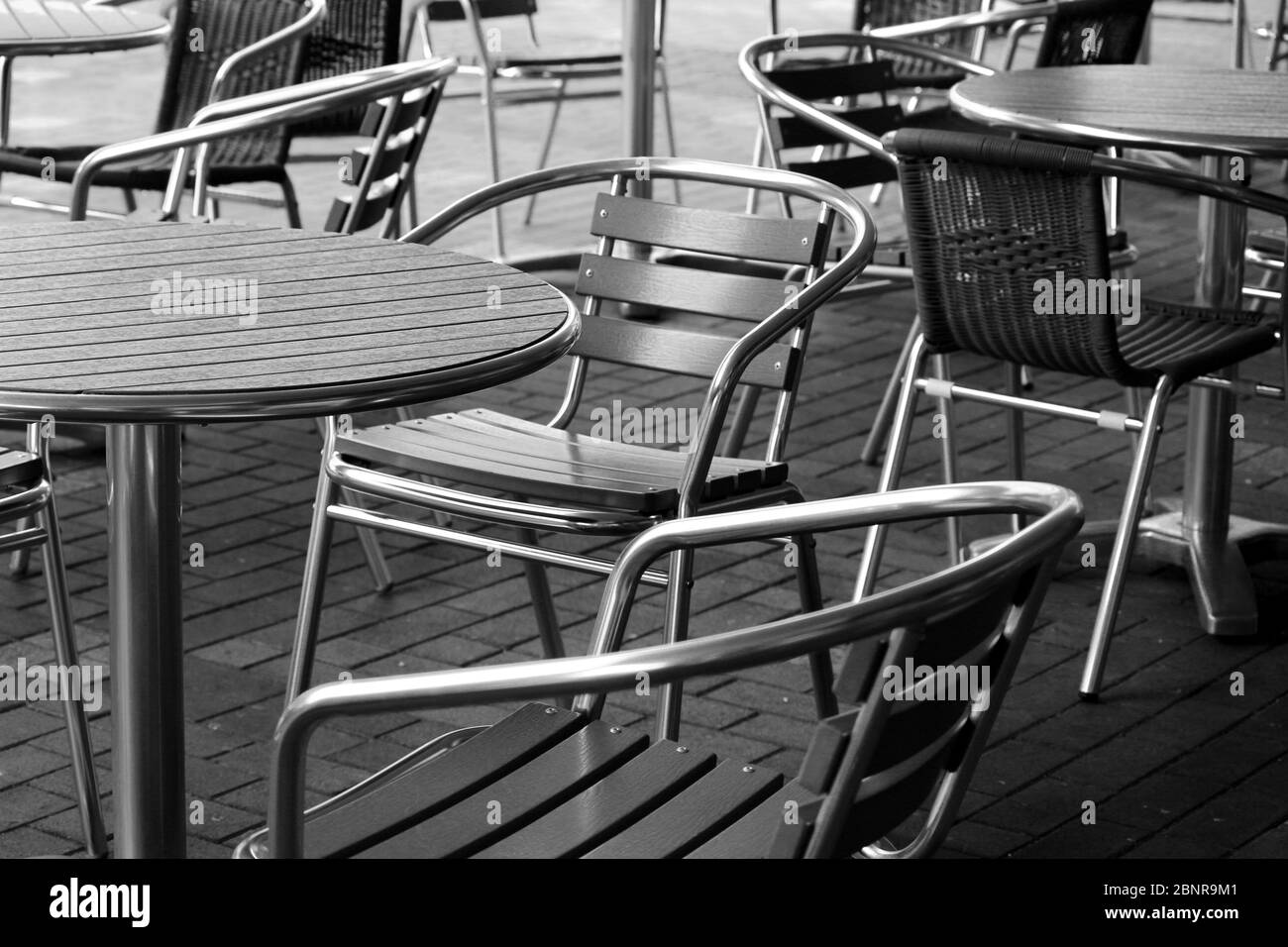 Garden tables lined up on a deserted terrace Stock Photo