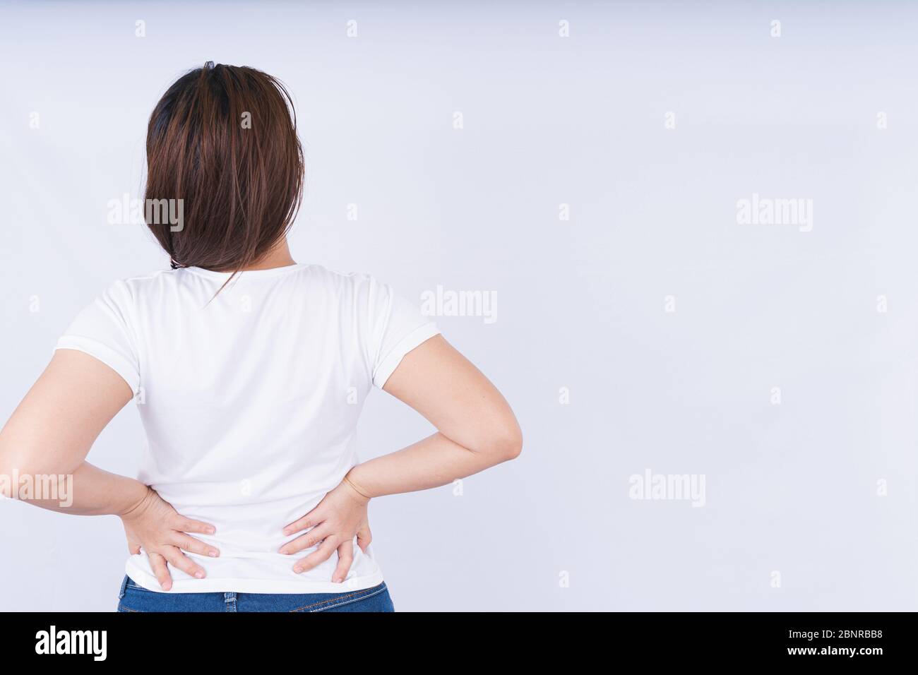 Female touching acute lower back pain on white background with copy space. Medical, healthcare for advertising concept. Stock Photo
