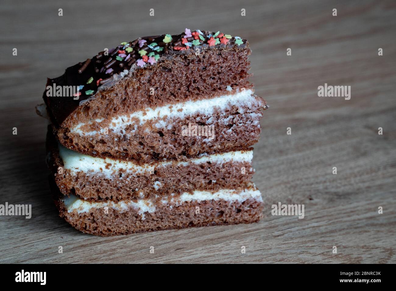 Chocolate Cake on the wooden background. One piece of sweet dessert with place for writing text Stock Photo