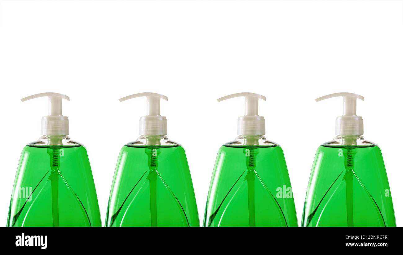Green liquid soap in plastic bottles in a row on white background Stock