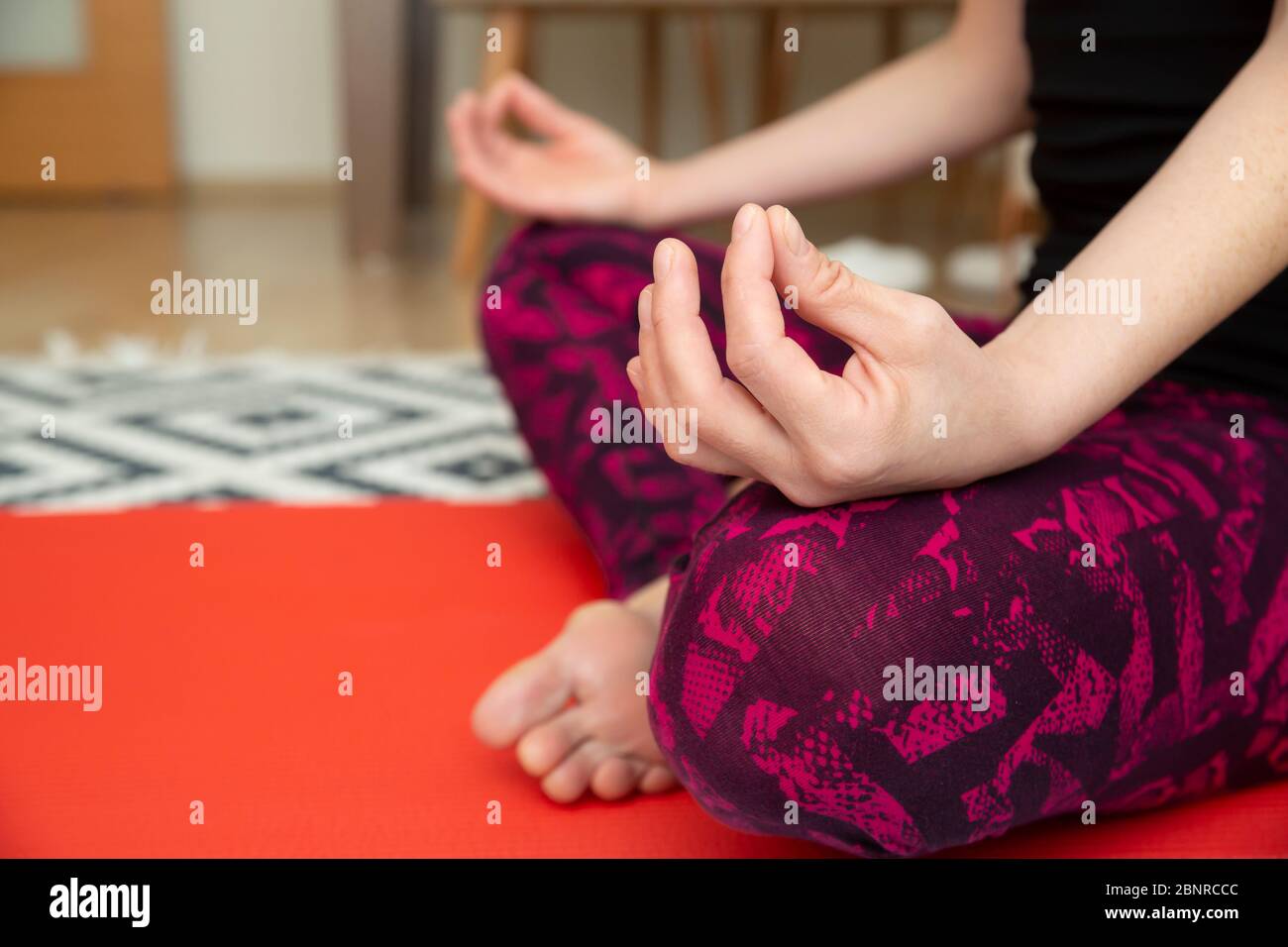 Beautiful young woman practicing yoga at home Stock Photo