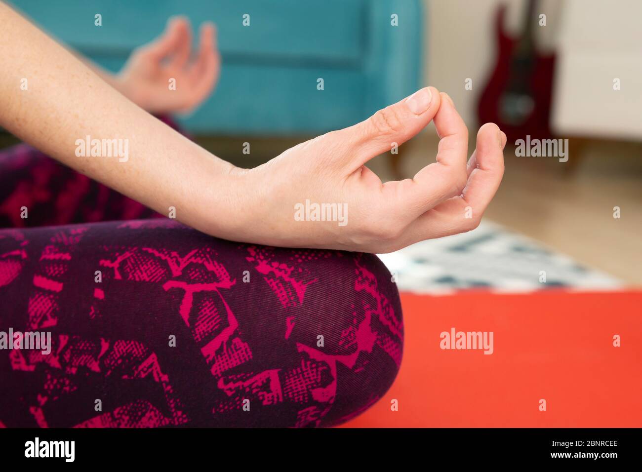 Beautiful young woman practicing yoga at home Stock Photo