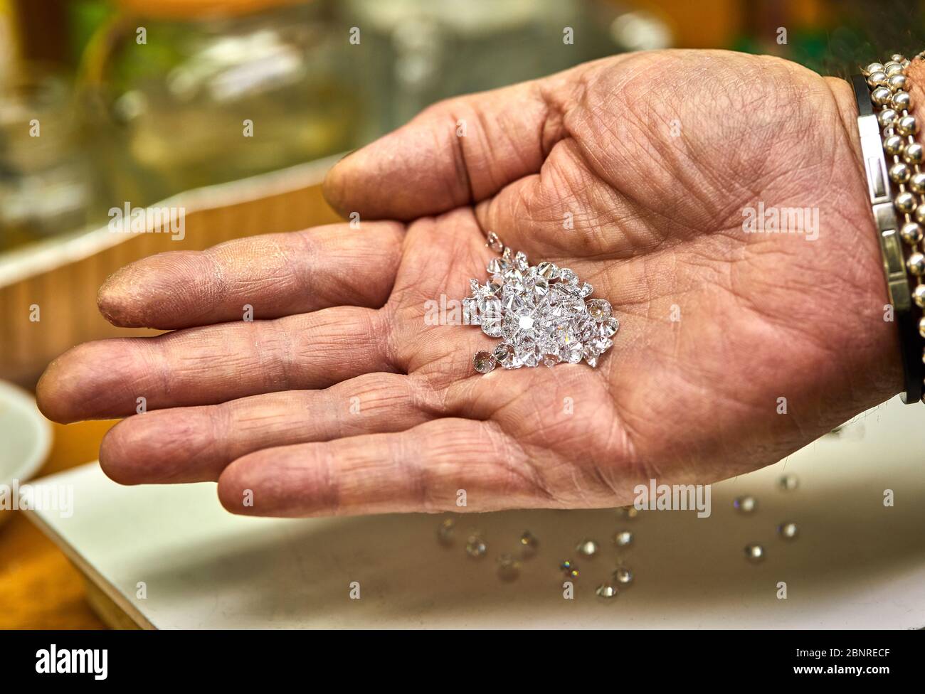Jewelry production. Fixer holds diamonds on the palm before fixing