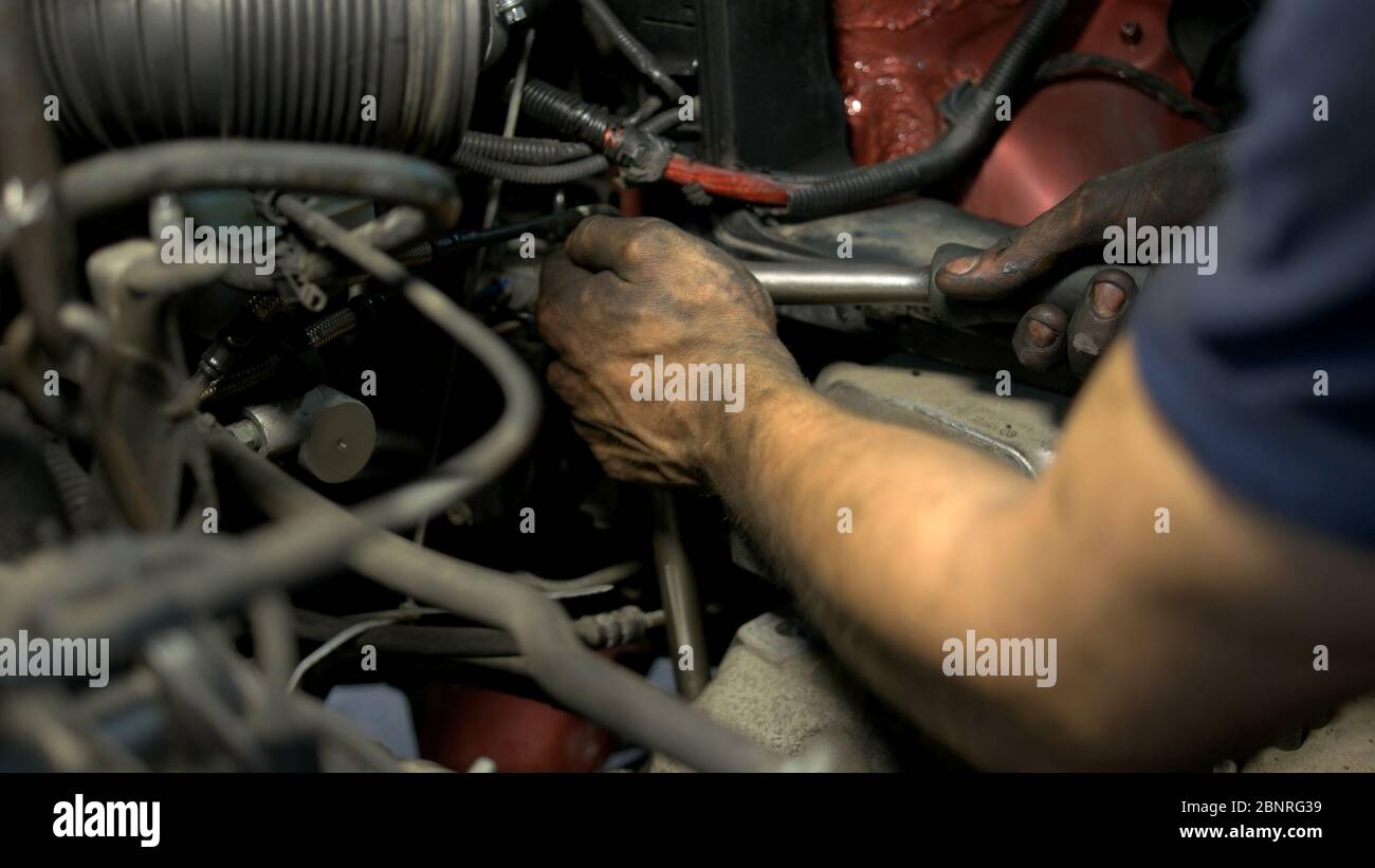 Close up mechanic hands fixing car engine mechanism. Stock Photo