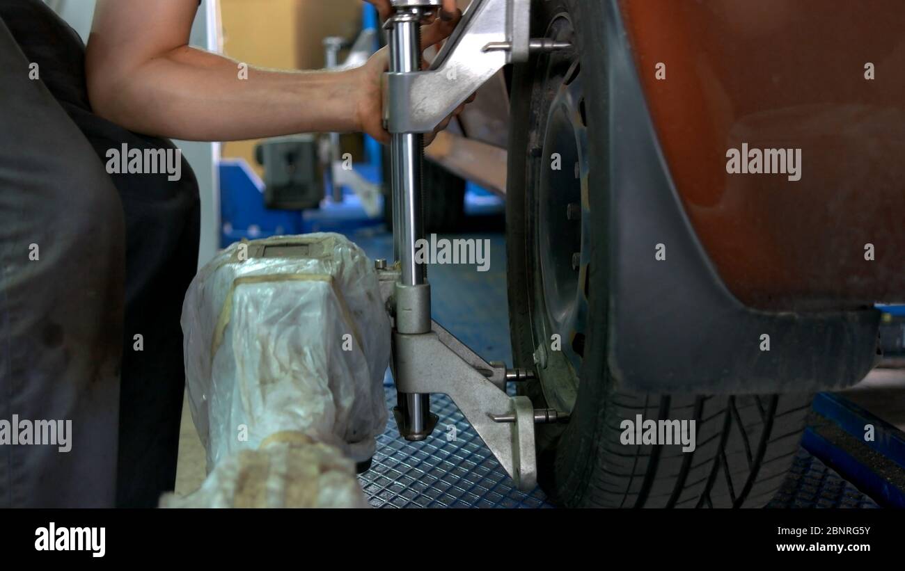 Engineer is setting camber caster gauge for checking alignment of tire