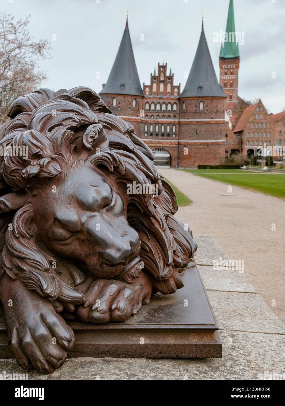 Sculpture of a sleeping lion in front of the Lübeck Holsten Gate, as a symbol for the standstill in the tourism industry. Stock Photo