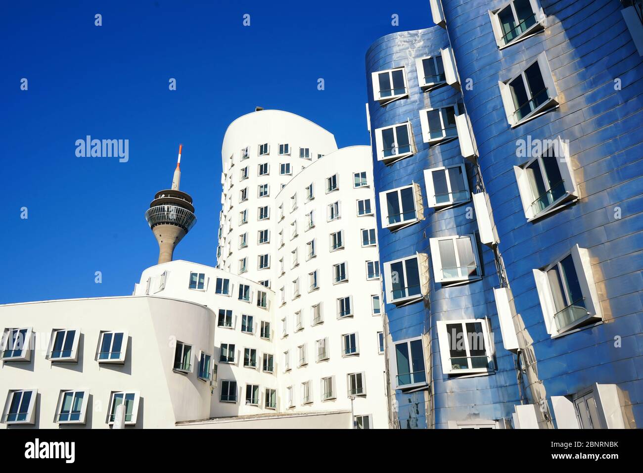 Buildings designed by the star architect Frank O. Gehry in Düsseldorf at 'Neuer Zollhof', Medienhafen /  Media Harbour. Sunny day with blue sky. Stock Photo