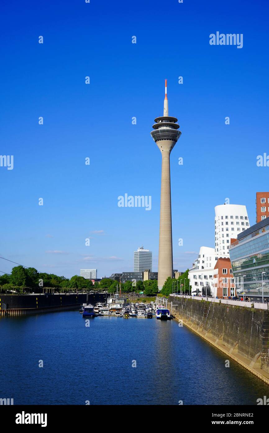 Panoramic view of Düsseldorf's landmark, the Rhine Tower (German: Rheinturm) at 'Neuer Zollhof', Medienhafen. Gehry buildings on the right. Stock Photo