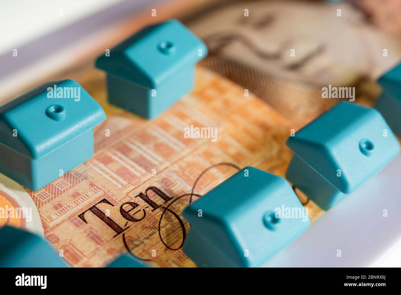Ten pound note with small blue houses,investment concept Stock Photo