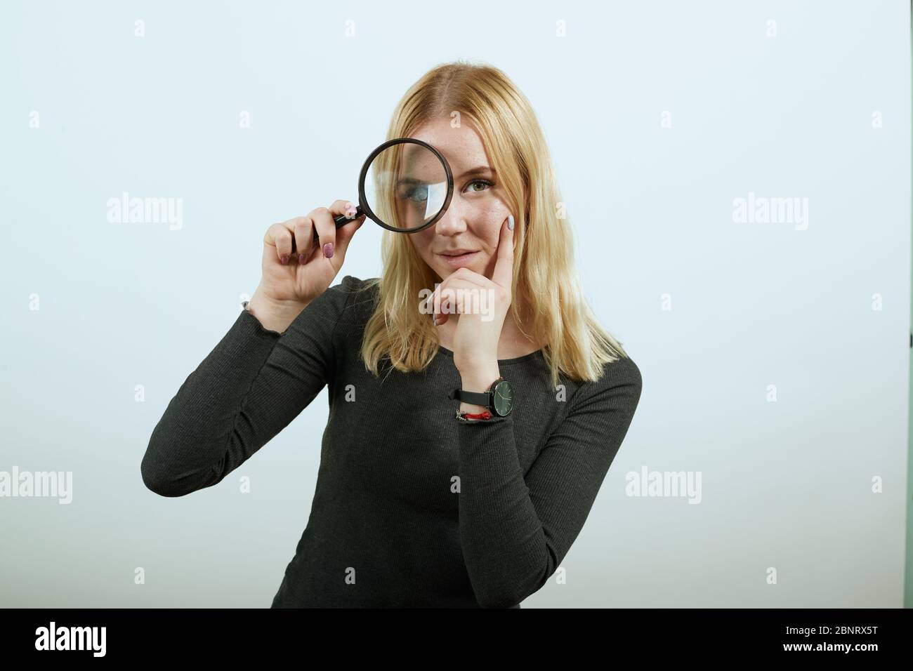 Woman looking through a giant magnifying glass Stock Photo