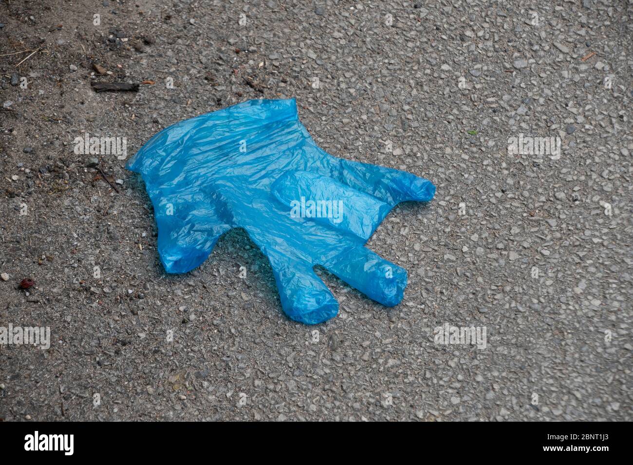 Sheffield UK May 13 2020 abandoned blue rubber glove discarded on the floor, protective PPE