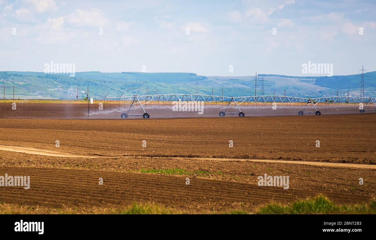 Field irrigation system. An irrigation pivot watering a field. Stock Photo