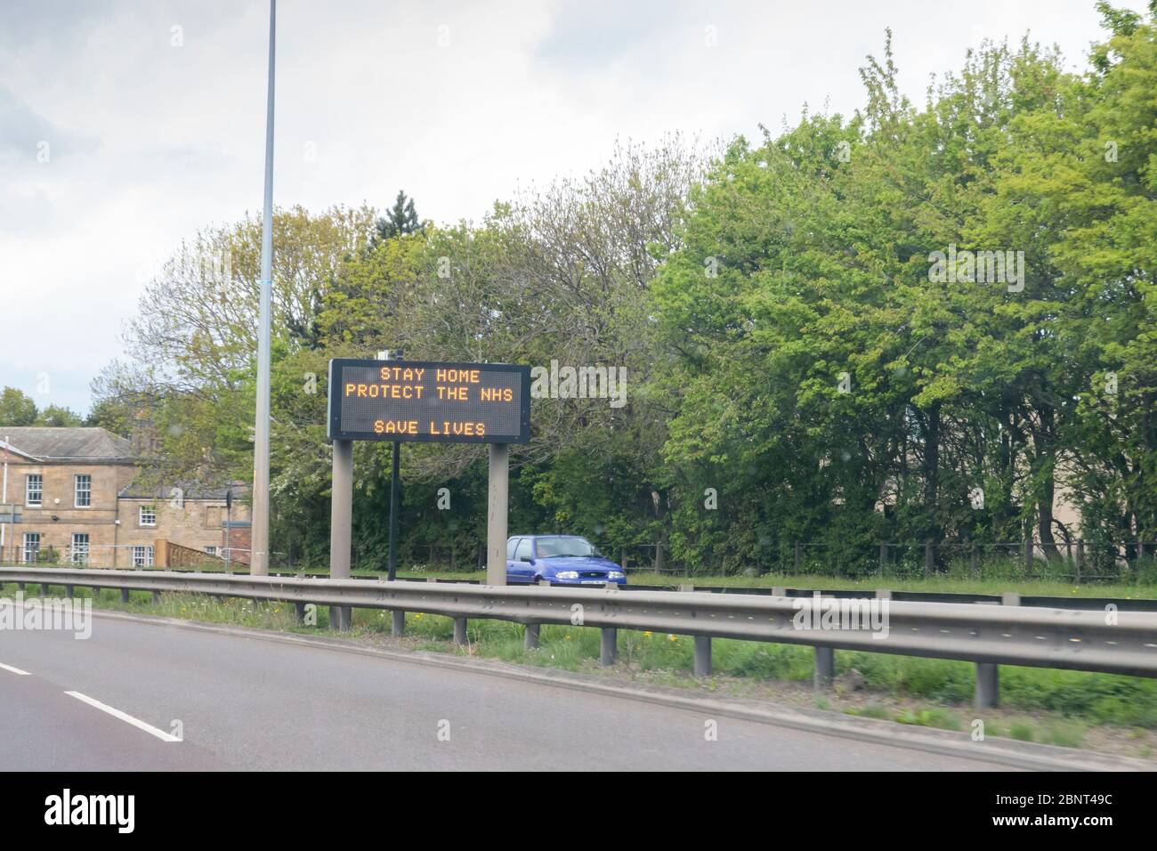 Newcastle/UK - 4th May 2020: Lockdown life in the Northeast. Motorway sign displays Stay Home Protect the NHS Save lives sign Stock Photo