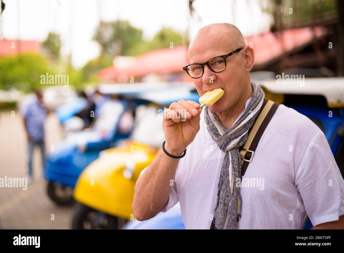 Portrait of senior tourist man eating ice cream in Ayutthaya Stock Photo