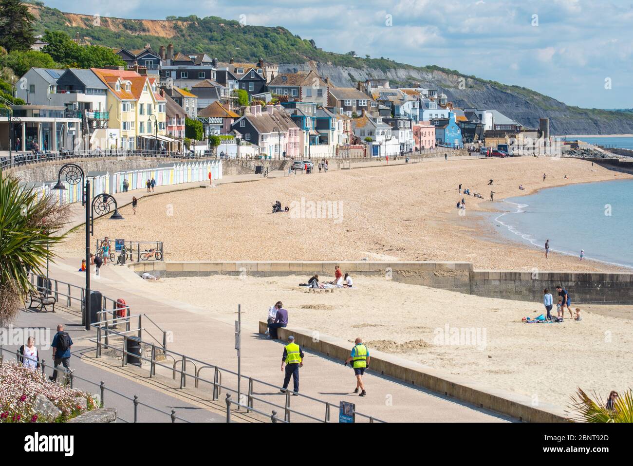 Lyme Regis, Dorset, UK. 16th May 2020. UK Weather: People start to return to the beach at Lyme Regis on the first sunny Saturday since the Government coronavirus restrictions were eased. The beach was busier than it has been since the start of the lockdown. Credit: Celia McMahon/Alamy Live News. Stock Photo